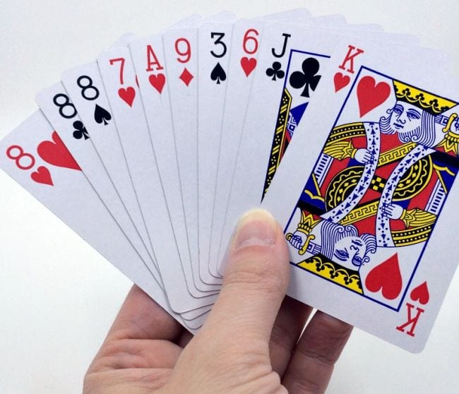 Student holding a handful of playing cards