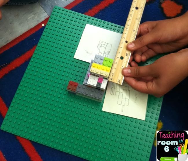 Student using a ruler to measure a small pile of LEGO bricks
