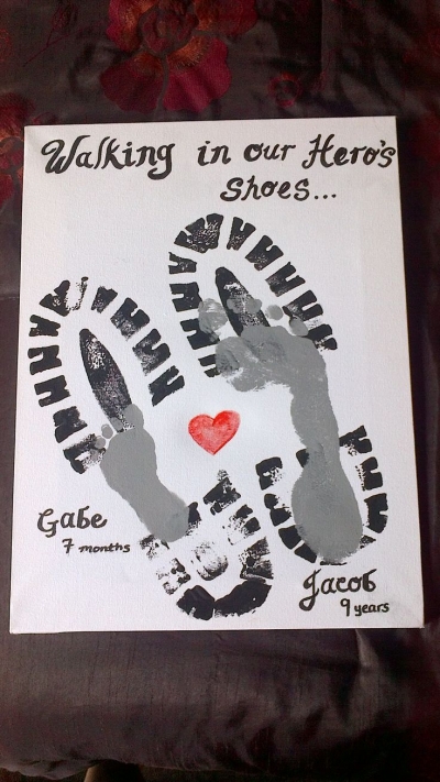 Father's Day crafts for kids that include footprints and handprints like this one are popular. Men's size shoe prints are overlayed with a child's footprint.